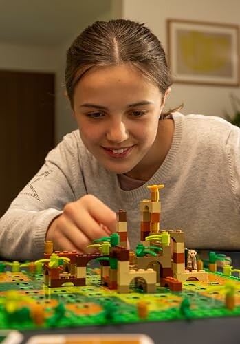 Child playing with a LEGO set featuring a small structure