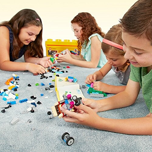 Children playing with LEGO bricks on the floor.