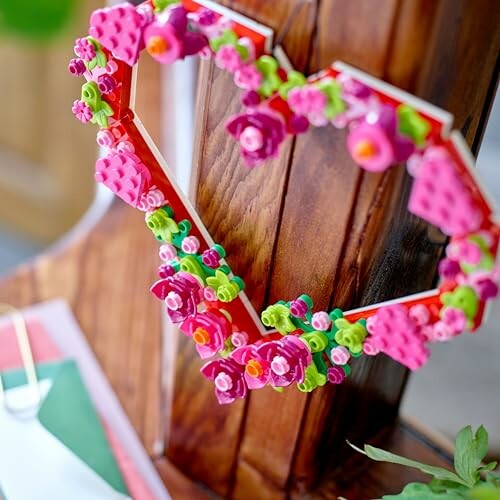Heart-shaped decoration with colorful flowers on a wooden surface.