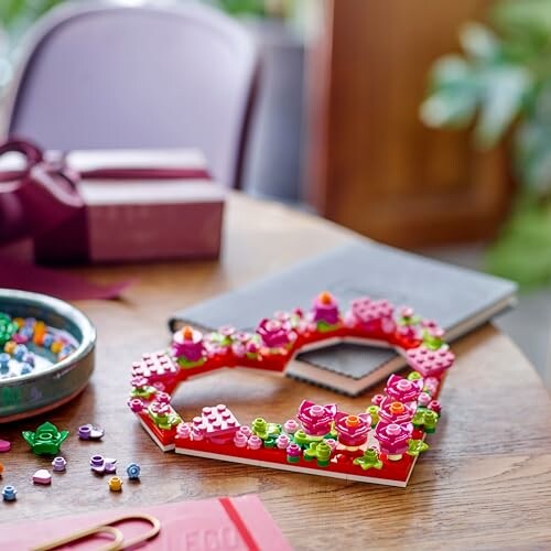 Heart-shaped LEGO decoration on a table with scattered pieces.