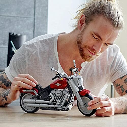 Man assembling a detailed motorcycle model.