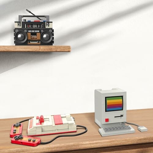 Retro-style LEGO models of a vintage computer, game console, and boombox on wooden shelves.