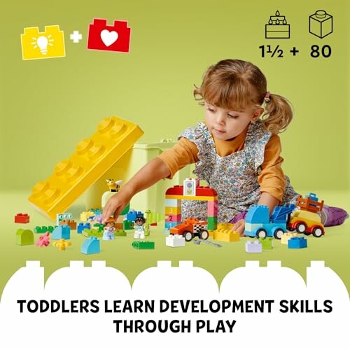 Toddler playing with colorful building blocks on a green background.