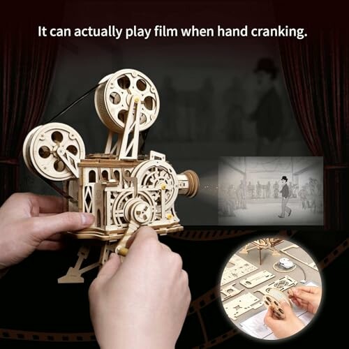 Hands operating a wooden film projector model with film scene displayed.