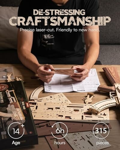 Person assembling a wooden model kit with tools and instructions.