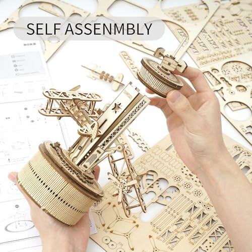 Hands assembling a wooden mechanical model kit