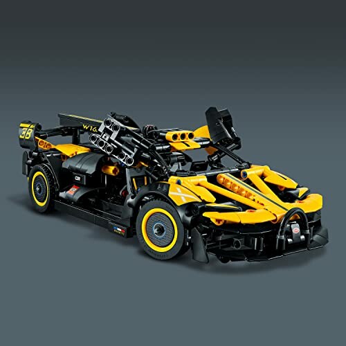 Yellow and black toy racing car on a gray background